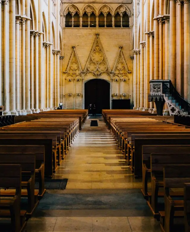 An empty church sanctuary with wooden pews
