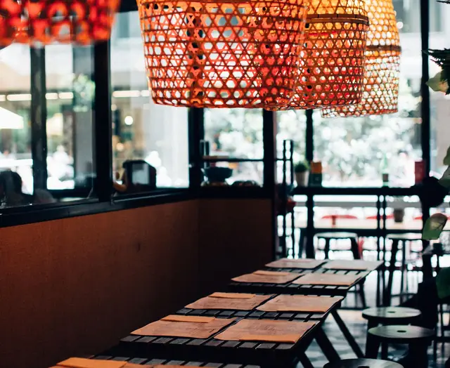 A warm dining room with woven lamps